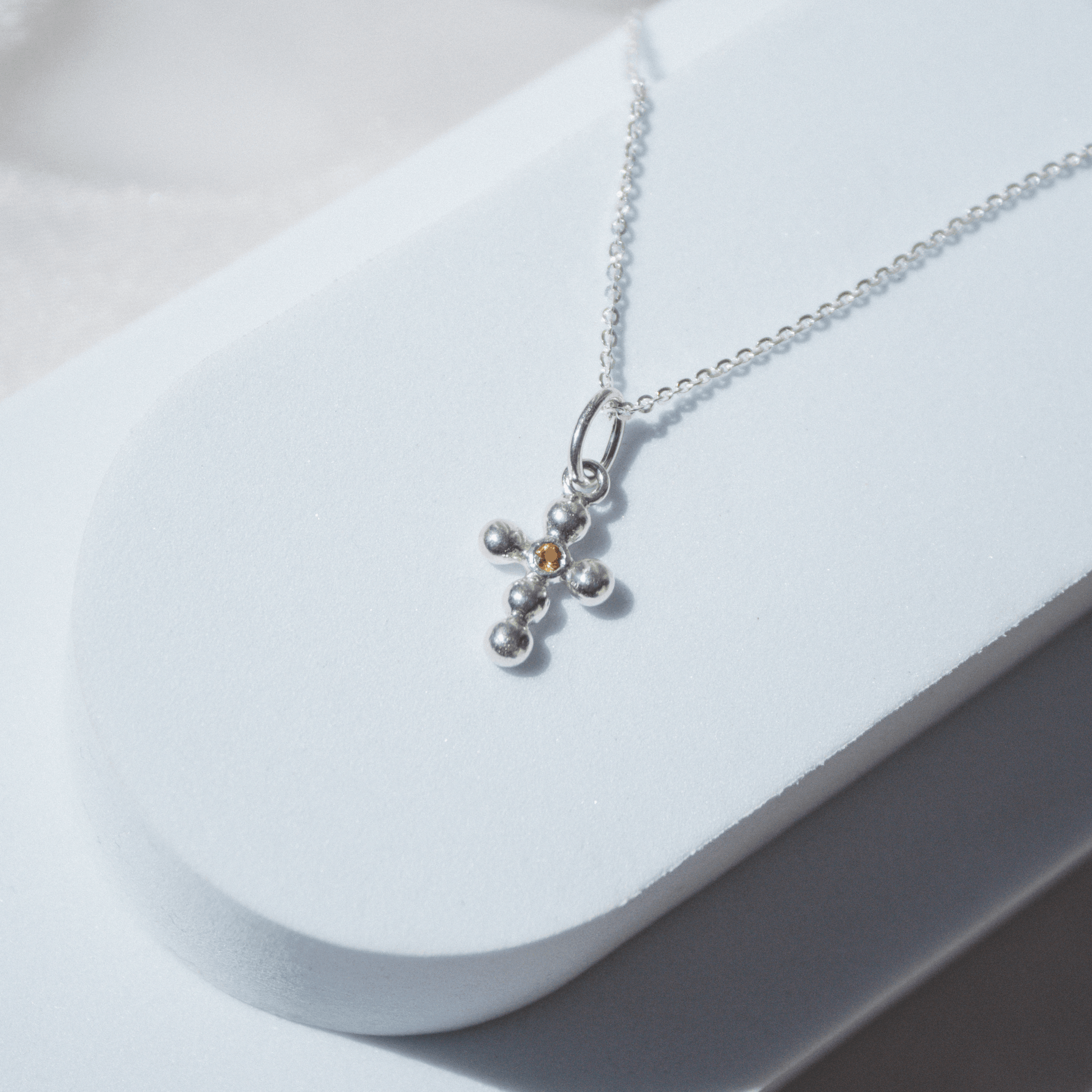 Collar Cruz Agnus naranja escenario