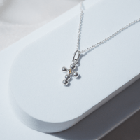 Collar Cruz Agnus naranja escenario